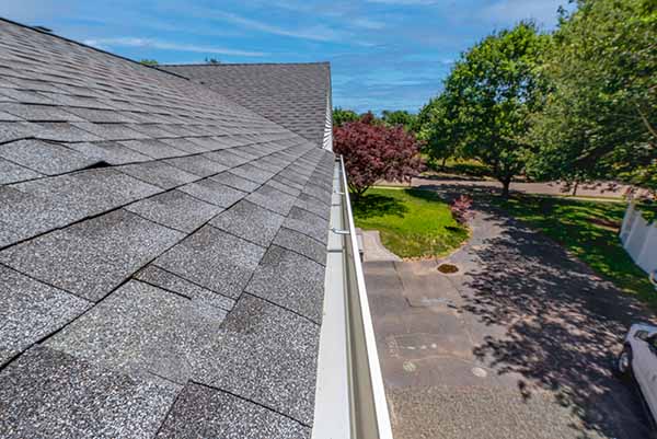 House with gray asphalt shingles and white seamless gutters